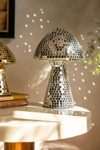 The Large Disco Mushroom Ornament displayed on a table in the sunshine, reflecting light onto the wall behind.