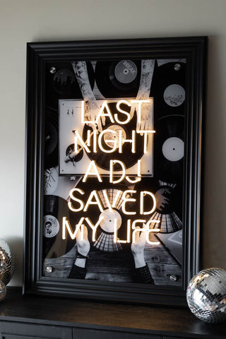 The Last Night A DJ Saved My Life... Framed Neon Wall Light with a black frame styled against a white wall.