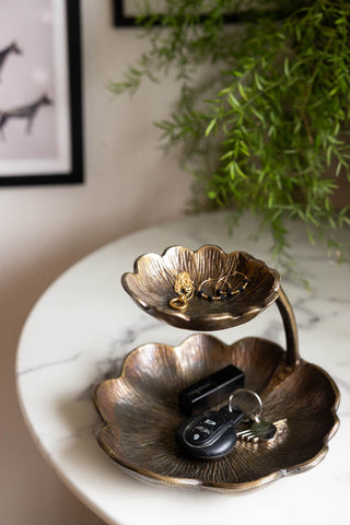 Lifestyle image of the Lily Pad Display Double Dish displayed on a marble table, with jewellery and keys inside. There is a plant and some art prints in the background. 