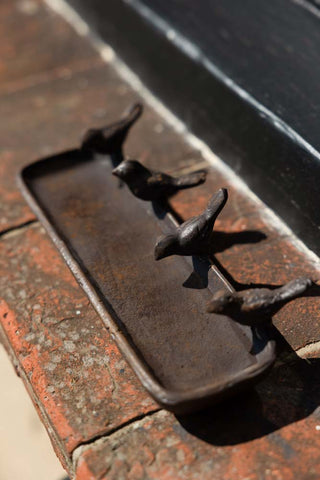 The Love Birds Tray displayed on a brick step.