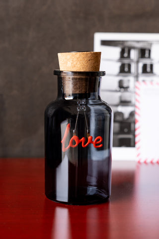 The Love Neon Bottle Light switched off and displayed on a wooden surface.