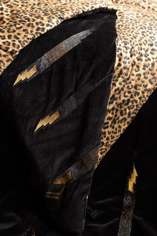 A close up image of the art and detailing on the Reversible Black Lovestruck & Leopard Print Blanket.
