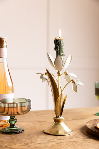 Lifestyle image of the Metal Floral Candle Holder against a light background on a dining table.