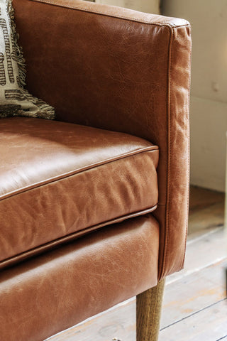 A detail image of the arm of The Mid-Brown Vintage-Style Leather Armchair showing the piping and the stitching