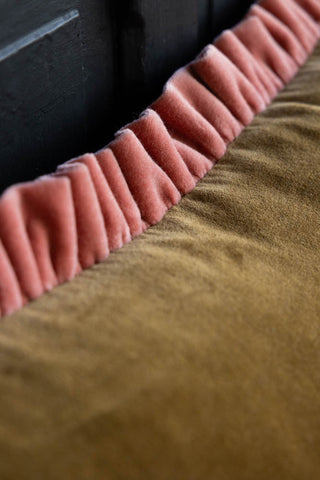 Close-up image of the Moss Green Velvet Cushion With Pink Ruffle