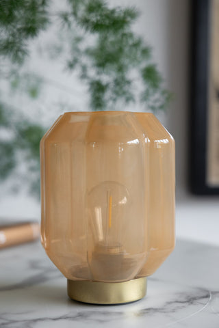 Close-up image of the Orange & Gold Battery Powered Table Lamp displayed on a white marble table.