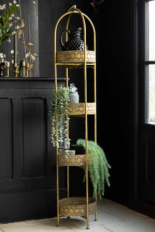 Lifestyle image of Ornate Gold Tall Tray Shelves styled with various other home accessories. 
