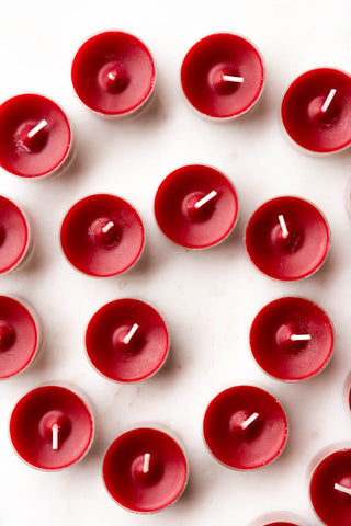 The Pack of 20 Tealight Candles in Deep Red on a whtie surface, seen from above.