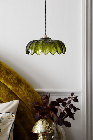 Lifestyle image of the Gold & Green Pendant Desert Island Light hanging above a bed with soft furnishings and decorative accessories