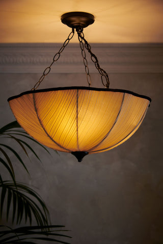 Lifestyle image of the Pleated Fabric Ceiling Light illuminated. 
