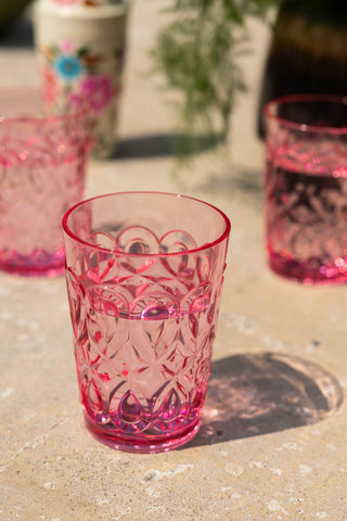 A sunny image of the The Pretty Embossed Pink Water Tumbler with a shadow of the pattern from the tumbler