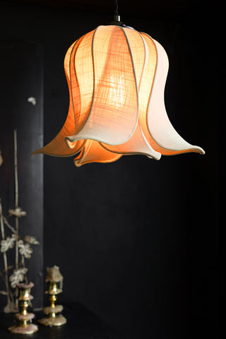 The Pretty Pink Petal Leaf Easyfit Lampshade lighting illuminated in front of a dark background.