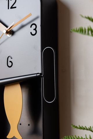 Detail shot of the Quirky Sardine Tin Pendulum Wall Clock.