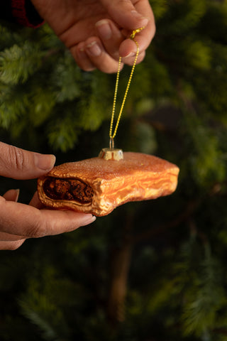 Lifestyle image of the Sausage Roll Glass Christmas Tree Decoration