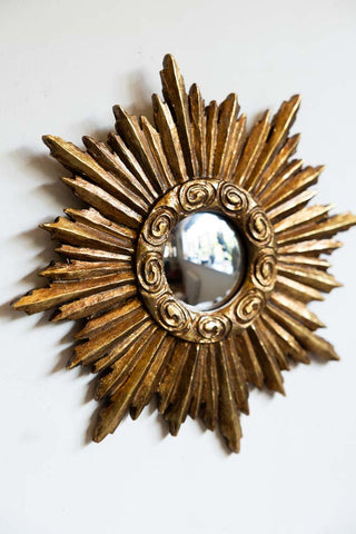 One of the Set Of 9 Assorted Ornate Gold convex mirror set on a white wall.