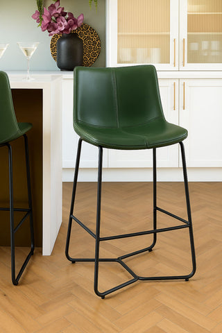 Green bar stools with black metal legs in a kitchen setting.