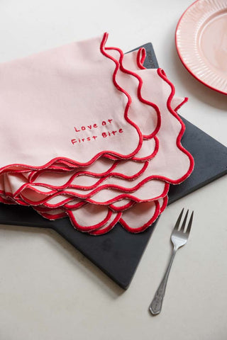 The Set of 4 Pink & Red First Bite Napkins styled next to a cake fork on a white countertop 