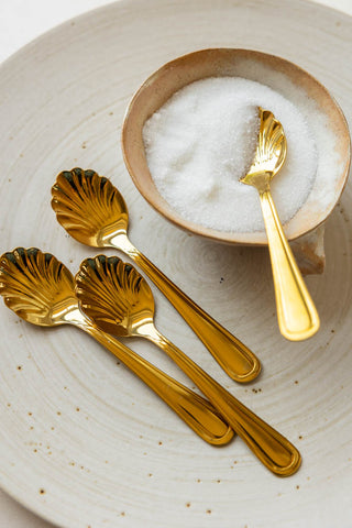 The Set of 4 Gold Shell Teaspoons styled with a bowl.