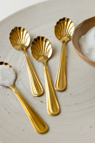 The Set of 4 Gold Shell Teaspoons displayed together next to a bowl.