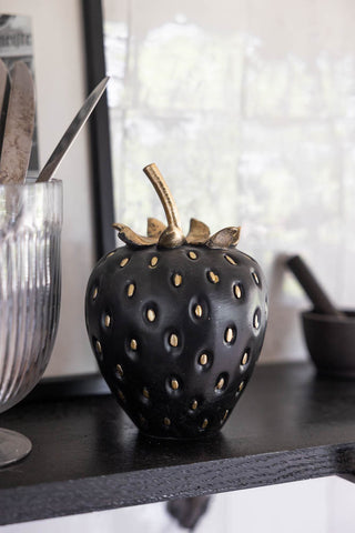 Little black strawberry ornament on a shelf