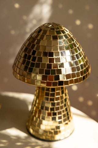 Detail image of the Small Disco Mushroom Ornament displayed on a table in the sunshine.