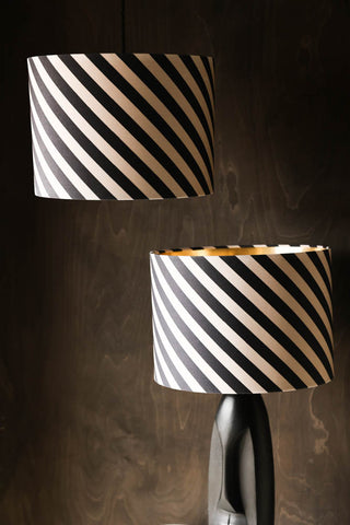 The Stripe Light Shade shown on a table lamp and as a hanging light on a wood backdrop.