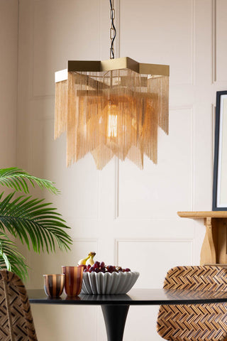 The Stunning Star Chain Chandelier hanging over a black dining table in a blush pink room.