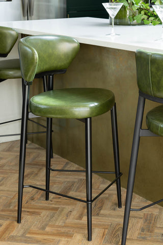 three  faux leather green bar stools on black legs at breakfast bar