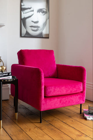 The Edie In Luxe Needlecord Velvet Harry's Pink Armchair styled with a side table, art print and various accessories.