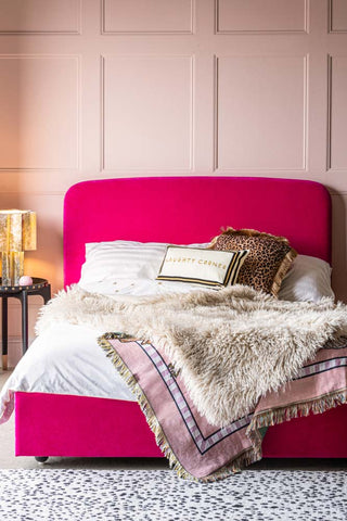 A styled image of the The Jagger Bed in Luxe Needlecord Velvet Harry's Pink with gorgeous white bedding on it.