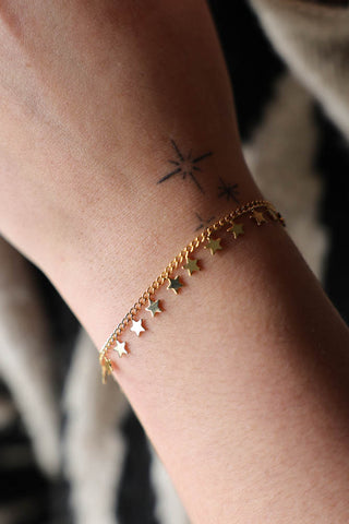 Lifestyle image of the You're A Star Charm Gold Bracelet displayed on a wrist. 