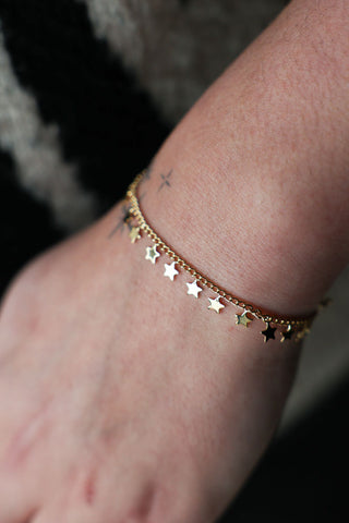 Lifestyle image of the You're A Star Charm Gold Bracelet displayed on a wrist.