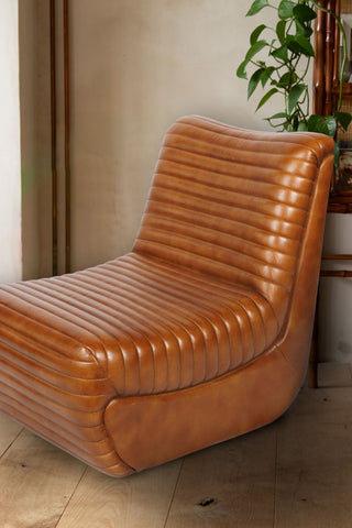 Close shot of the Traditional Brown Leather Occasional Chair styled in front of a wall with some greenery.