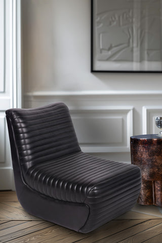 The Traditional Charcoal Leather Occasional Chair styled in a room next to a side table.