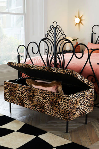 The Velvet Leopard Print Ottoman Storage Bench styled and open and the end of a bed.