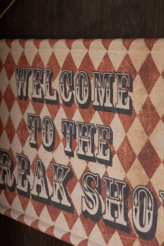 The Vintage-Style Freak Show Wall Art displayed on a dark wall.