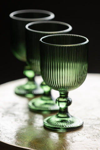 Three of the Vintage Style Red Wine Glass - Green in a row on a table.