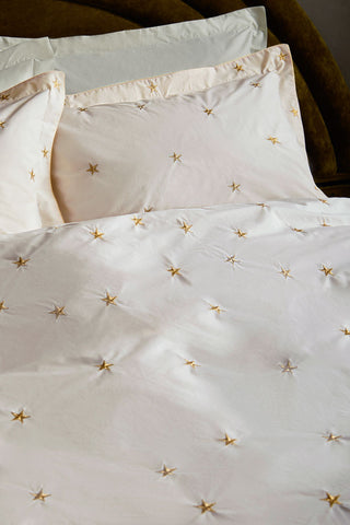 Lifestyle image of the White Falling Star Duvet Cover and Pillow Case Set displayed on a bed.