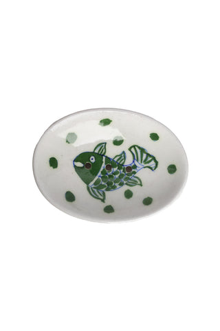 Image of a cutout of a white and green fish soap dish in front of a white background. 