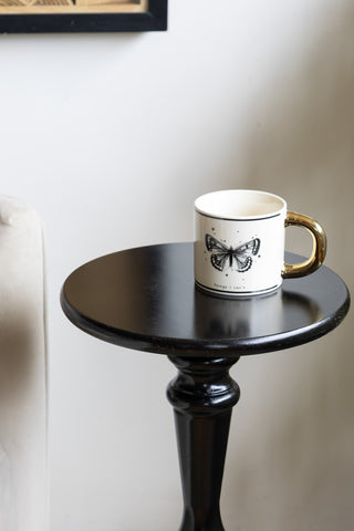 Close-up of the top of the Wood Turned Black Side Table with a mug on.