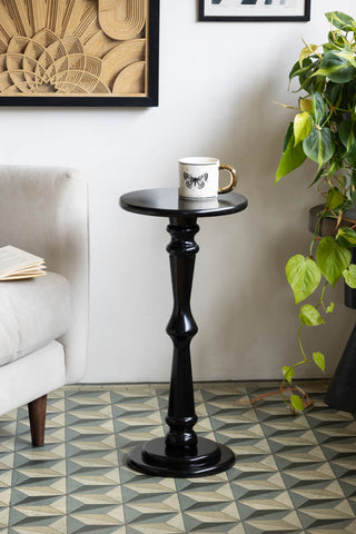 The Wood Turned Black Side Table styled in a living room with a mug on.