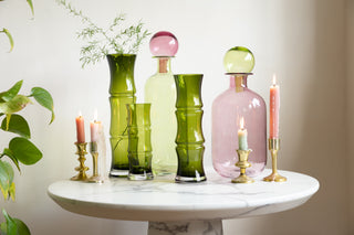 Beautiful lifestyle image of green and pink vases on a coffee table.