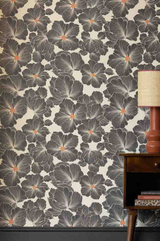 Rockett St George Bohemian Bloom wallpaper features large black and white flowers with bright orange centres. The flowers are oversized and bold in design. 