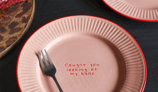 The Pink & Red First Bite Side Plates Set of 4 displayed on a dark wood table, with a fork and serving board.