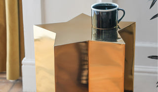 The Shiny Gold Star Side Table with a mug displayed on the top.
