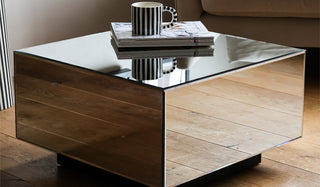 Lifestyle image of the HKliving Mirror Block Coffee Table styled with a mug and stack of magazines.