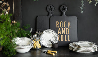 Lifestyle image of new kitchenware products styled together on a black sideboard with various plants.