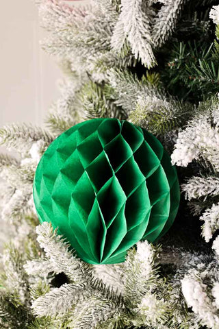 Small green honeycomb paper ball hanging for christmas tree branches.