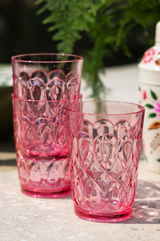 Three of the Pretty Embossed Pink Water Tumblers styled together on an outdoor table.