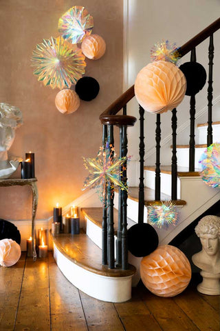 Peach honeycomb decorations styled on a bannister and the wall.